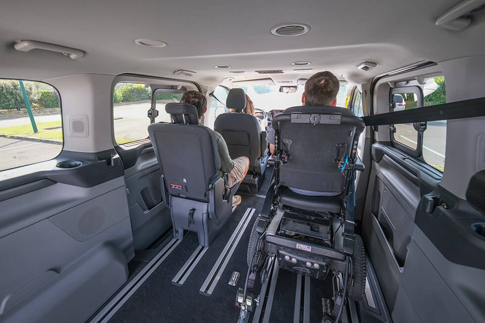 Le Ford Tourneo Custom Ecoline permet au passager en fauteuil roulant de s'installer juste derrière le conducteur et le passager avant